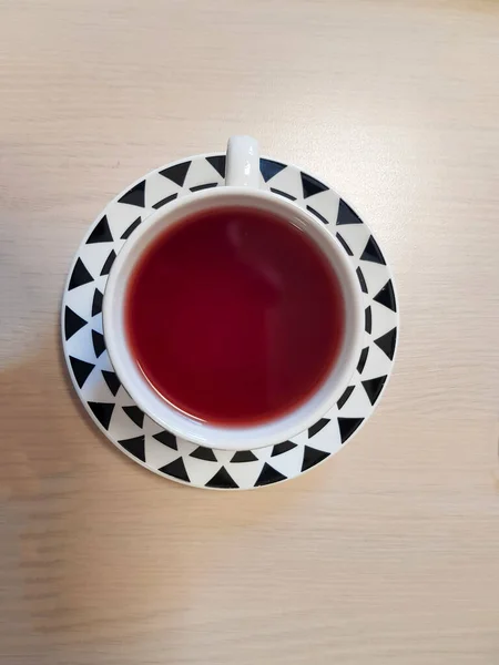 Siyah beyaz desenli bir fincanda çay. Fotoğraf yukarıdan çekildi.