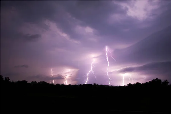 Lightning streak from a thunderstorm cloud at night. Multiple lightning strikes coming from the thunderstorm.