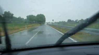 Düz yolda yağmurlu bir araba yolculuğu, bulutlu yağmurlu bir hava.