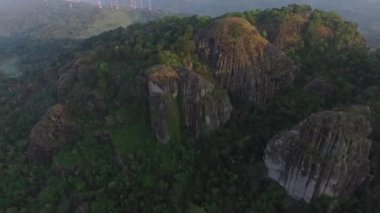 Sabahları yeşil ormanlı bir dağ manzarası.