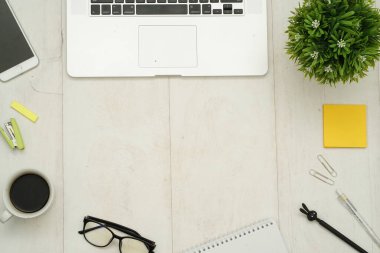 Üzerinde bilgisayar cihazları, akıllı telefon, ofis malzemeleri ve kahve olan masa başı çalışma masasının fotokopi alanı olan en iyi manzara. Düz yatıyordu.