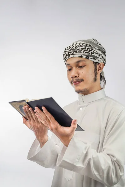 모슬렘 남자가 배경에 고립된 코란을 — 스톡 사진