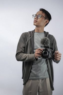 Profesyonel kameralı Asyalı genç fotoğrafçı beyaza izole edilmiş.