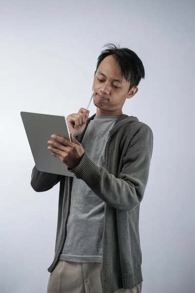Retrato Jovem Asiático Confuso Pensando Enquanto Trabalhava Computador Tablet Isolado — Fotografia de Stock