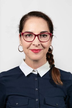 Mavi gömlekli ve gözlüklü sevimli bir kadının fotoğrafı..