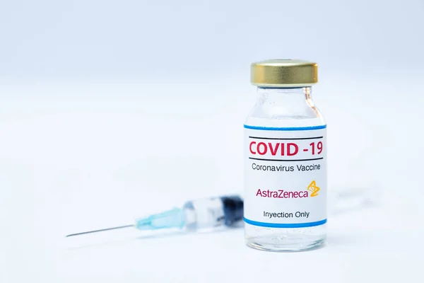 Flacone di vaccino coronavirus con logo Astra Zeneca e sfondo della siringa. — Foto Stock