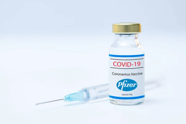 Flacone di vaccino coronavirus con il logo Pfizer e lo sfondo della siringa. — Foto Stock