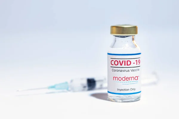 Flacone di vaccino coronavirus con il logo Moderna e lo sfondo della siringa. — Foto Stock