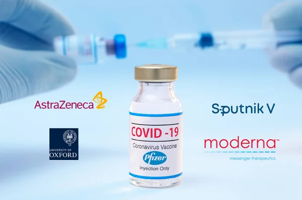 Bottiglia di vaccino Pfizer coronavirus con i loghi Sputnik V, Moderna, Astra Zeneca e Oxford University sullo sfondo. — Foto Stock