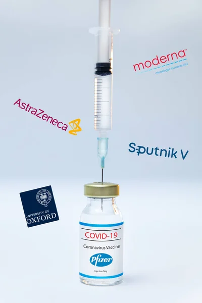 Flacone di vaccino Pfizer coronavirus con loghi e siringhe Sputnik V, Moderna, Astra Zeneca e Oxford University sullo sfondo. — Foto Stock