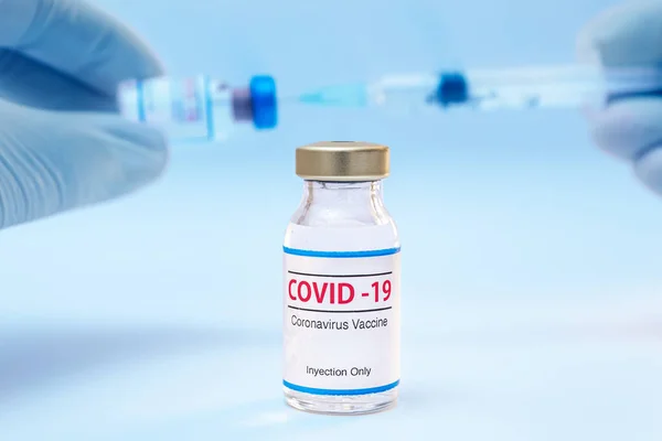 Flacone di vaccino coronavirico e mani di medico con sfondo siringa — Foto Stock