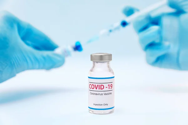 Flacone di vaccino coronavirico e mani di medico con sfondo siringa — Foto Stock