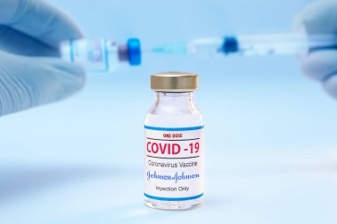 Bir doz Coronavirus Jhonson ve Jhonson aşısı ve şırınga geçmişi olan doktor elleri..