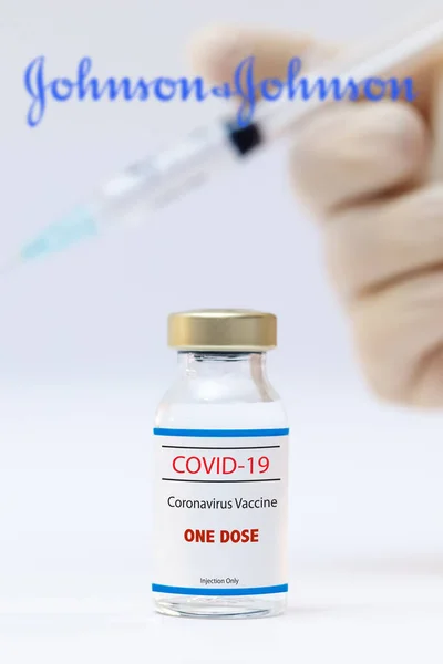 Flacone di vaccino coronavirus monodose e logo jhonson e jhonson come sfondo. — Foto Stock