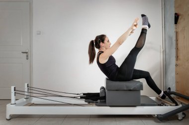 Islah olmuş bir yatakta pilates egzersizi yapan bir kadın..