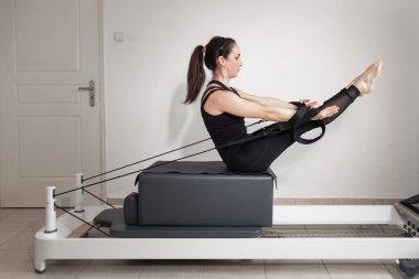 Islah olmuş bir yatakta pilates egzersizi yapan bir kadın..