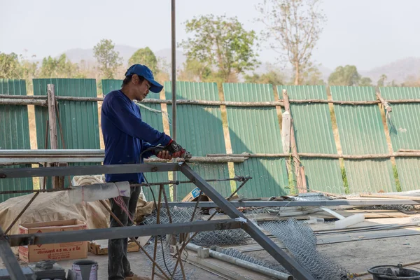 Un hombre trabajadores cortan marco de hierro — Foto de Stock