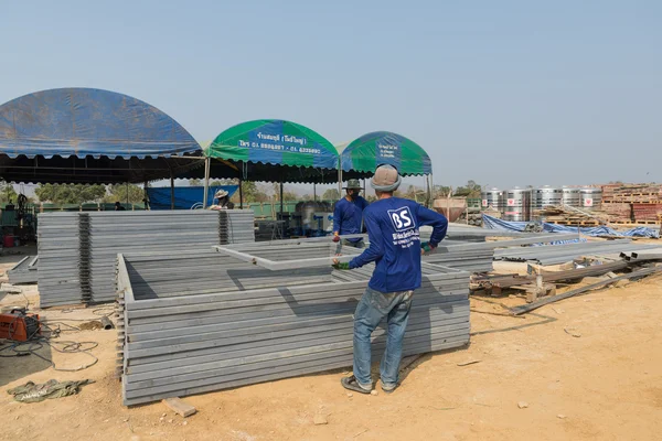 Dos trabajadores sostienen marco de hierro — Foto de Stock