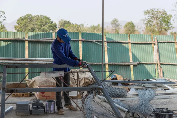 Un hombre trabajadores cortan marco de hierro — Foto de Stock