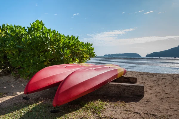 Two red-yellow kayak turn on the beach near sea — Stock Photo, Image