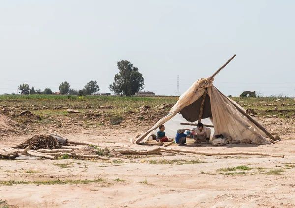 Een jongen helpt zijn vader te wassen van de hand in de shelter op de dr — Stockfoto