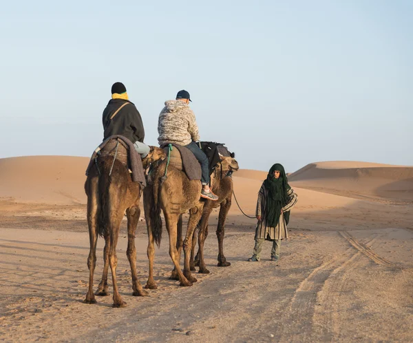 Der arabische führer mit ein paar touristen in der sahara-wüste — Stockfoto