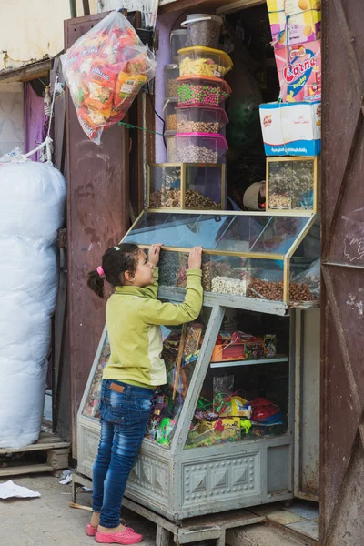 アフリカの女の子がモロッコの雑貨店からスナックを買う — ストック写真