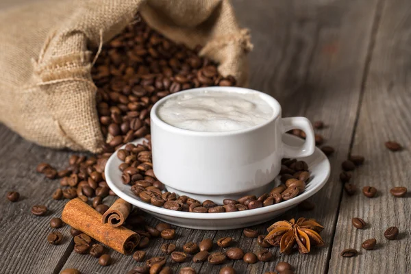 Xícara de café, canela e saco de café — Fotografia de Stock