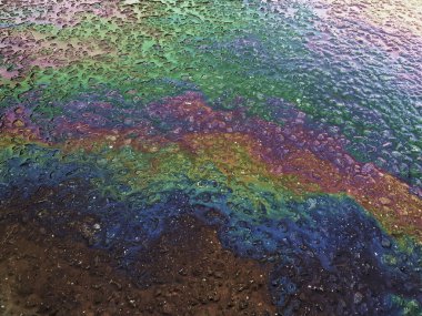 Asfalt Yolu 'ndaki benzin lekelerinin rengi. Zemin kirliliği konsepti