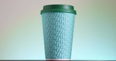 Yeşil kağıt kahve fincanı dönüyor. Sıcak içecekler için tek kullanımlık bardak. Kahve çekirdekleri kabartmalı. Espresso, latte, cappuccino hazır.