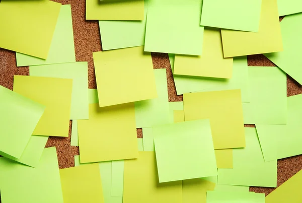 Image of blank green and yellow sticky notes on cork bulletin bo — Stock Photo, Image