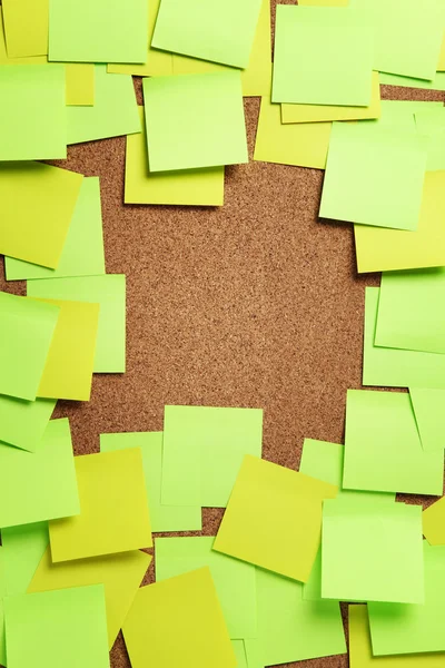 Image of blank green and yellow sticky notes on cork bulletin bo — Stock Photo, Image