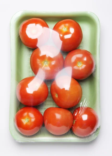 Imagem de embalagem de plástico de tomates da loja no fundo branco — Fotografia de Stock