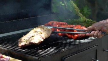 Yavaş yavaş şefin leziz ızgara et ile barbekü pişirmesi. Domuz pirzolası ve ızgarada kızartılan kırmızı biber.
