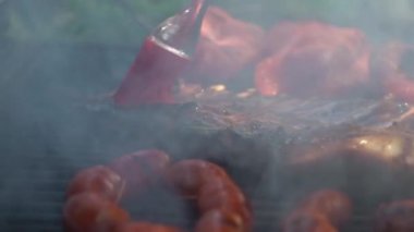 Yavaş çekim şefi barbekü ızgarası için domuz pirzolası ve sosa lezzetli sos koydu. Tatil tatillerinde Bahçe Evi 'nde barbekü için ızgara et yakın. İspanya 'da yemek pişiren adam