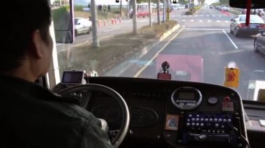 4K, yaşlı bir erkek direksiyonun yakın çekimi, bir otobüste direksiyon, yolcuyu sürüyor. Umumi bir karayolu aracında taşımacılık ve insanları taşımak, tipik olarak bir güzergah ve ücret karşılığında halka hizmet etmek.
