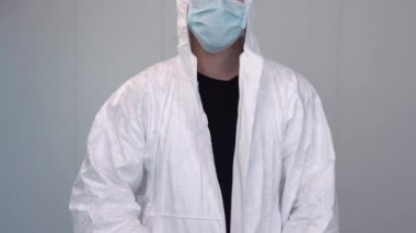 Covid salgını sırasında koruyucu giysi giyen bir sağlık görevlisi. Hemşire hastane ya da klinikte PPE kıyafeti, eldiven ve cerrahi maske takıyor..