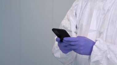 4K, PPE 'deki doktor ve el eldiveni kullanıyor. Covid-19 salgını sırasında akıllı telefondan mobil uygulamalara danışmanlık yapıyor. Kişisel koruyucu ekipmanlarda sağlık çalışanı. Teletıp kavramı