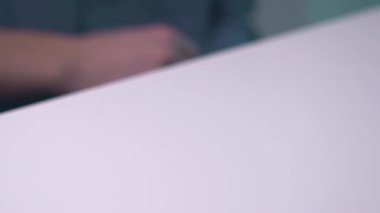 Kafkasyalı adamın dizüstü bilgisayarı kullanması ve beyaz masa üzerindeki klavyenin tuşuna basması. İş yerinde defterle çalışmak. İş büyümesi kavramı.