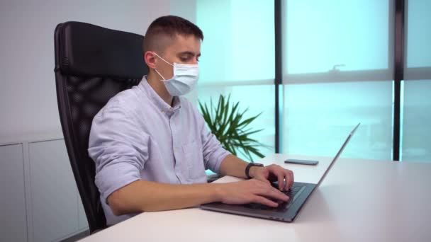 Young Man Freelancer Met Moderne Laptop Draagt Een Chirurgisch Masker — Stockvideo