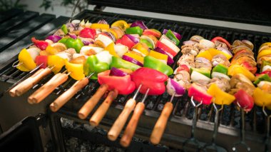 Şef ızgara etle barbekü pişiriyor. Arka bahçedeki barbeküde çok lezzetli bir brochette. Bir evin bahçesinde ızgara barbekü ile pişirilen yemekler.