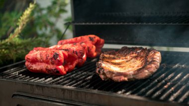 Barbekü ızgarasında kırmızı biberli domuz pirzolası pişirmek. Lezzetli bir ızgara et pişir. Izgara ızgarayla pişirilen yemekler. Şef bir evin arka bahçesinde domuz eti pişiriyor.