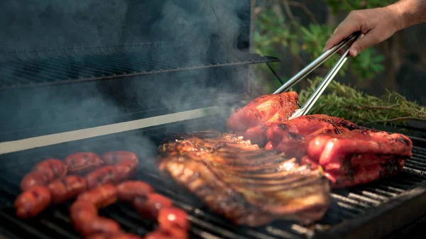 Ruka Muže Kovovým Tong Vaření Vepřové Žebírka Červenou Paprikou Grilu — Stock fotografie