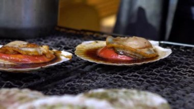 Tsukiji 'nin dış pazar caddesinde yavaş yemek pişirmek, pürmüz ve mangal ızgarasıyla taze Japon deniz tarlarını yakmak ve yakmak. Yemek satıcısı ocakta ateşle pişirildi.