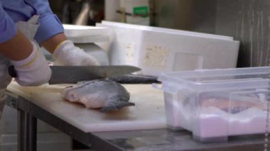 Yavaş çekimde insan, Tsukiji balık pazarında somon temizler ve onu hazırlar. Şef somon filetosu kesiyor ve restoranın mutfağında yemek hazırlıyor. Tokyo-Dan Japon deniz ürünleri pazarı