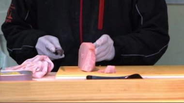 Aşçıbaşı yavaş yavaş taze ton balığı hazırlıyor, restoranda tahtayı bıçakla kesiyor. Adam Tokyo 'daki ünlü pazar yerinde popüler Japon yemekleri pişirdi. Sağlıklı yiyecekler. Kavram Dan.