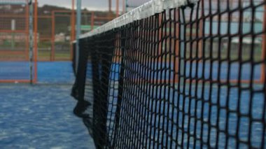Mavi kortta tenis topunun ağlara vuruşunun yavaş hareketi. Kürek çeken insanlar. Yakın çekim sarı toplar ağa çarptı. Spor anlayışı. -Dan.