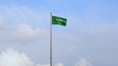 Suudi Arabistan Krallığı bayrağı mavi gökyüzü ile rüzgarda dalgalanıyor. KSA afişi, yumuşak ve pürüzsüz ipek. Kumaş kumaş dokusu, Asteğmen. Bunu ulusal gün ve ülke etkinlikleri için kullan.