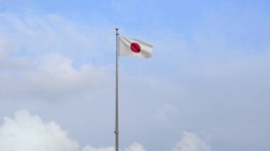 Mavi gökyüzüyle rüzgarda dalgalanan Japon bayrağı. Japonya afişini yakın çekin, yumuşak ve pürüzsüz ipek. Kumaş kumaş dokusu, Asteğmen. Bunu ulusal gün ve ülke etkinlikleri için kullan.