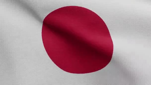日本の国旗が風に揺れる 日本のバナーを吹いて 柔らかく滑らかなシルクを閉じます 布生地の質感が背景を刻印 国民の日や国の機会の概念のためにそれを使用してください — ストック動画